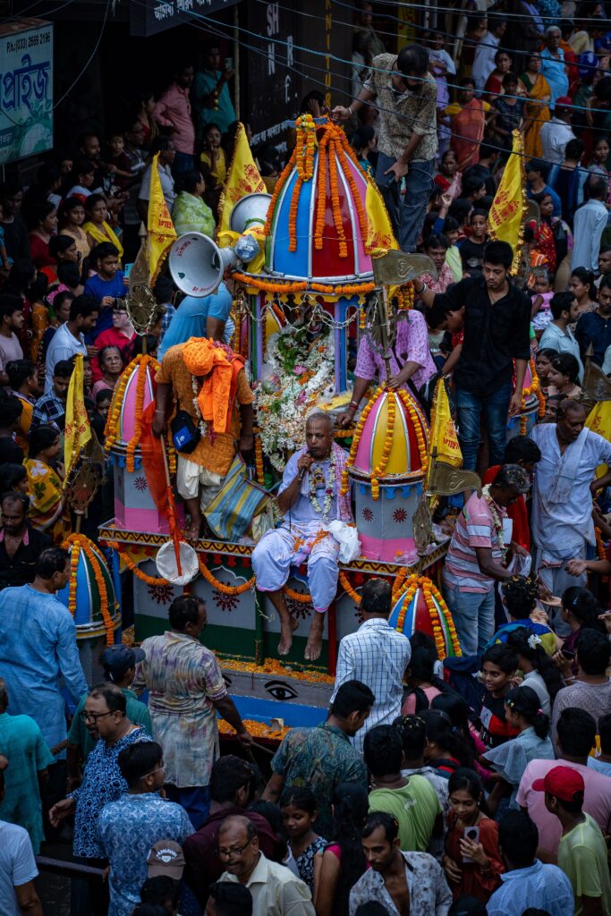 Colorful celebration of Rath Yatra festival in streets crowded with devotees in India.