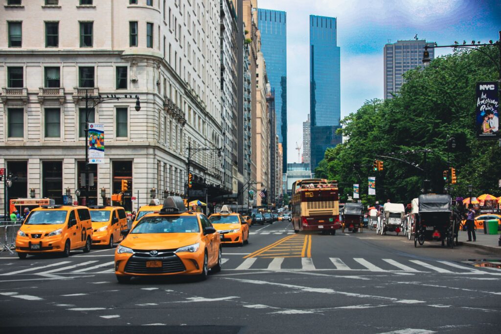Yellow taxis and bustling traffic on a vibrant New York City street.